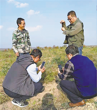 <p>　　李吉宁（后排右）给种植户培训中药材种植技巧。（图片由受访者提供）</p>