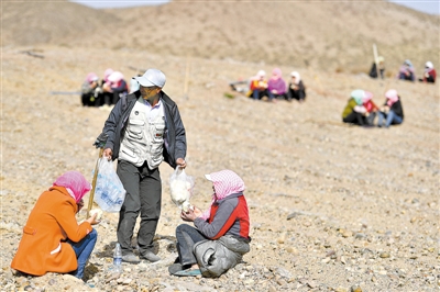 <p>　　李奇玲在山坡上为乡亲们分发馒头和矿泉水。</p>