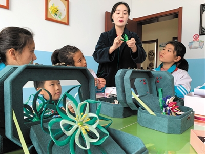 <p>　　第七小学学生围坐在圆桌前，倾听辅导老师讲解非遗项目“英山缠花”。</p>