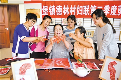 <p>　　　　德林村非遗工作室，非遗传承人在教村民学习剪纸。</p>